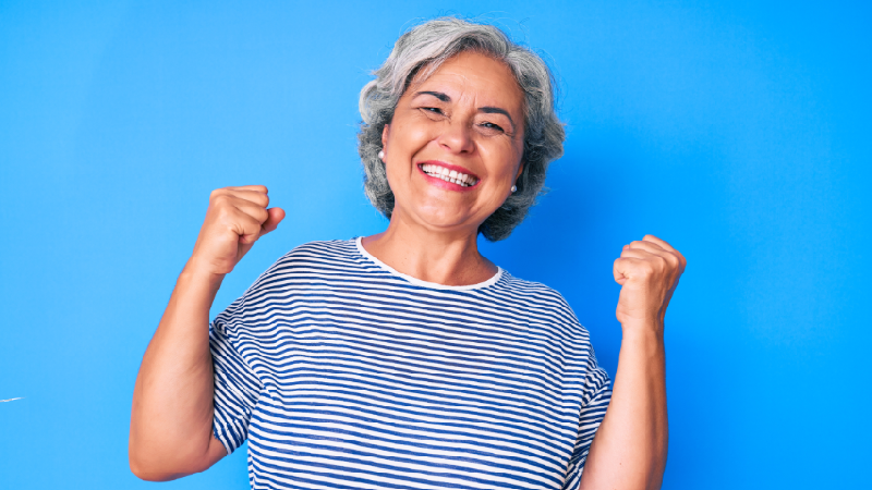 Mulher 60+ feliz por ter direito aos descontos em medicamentos oferecidos pelo Instituto de Longevidade MAG.