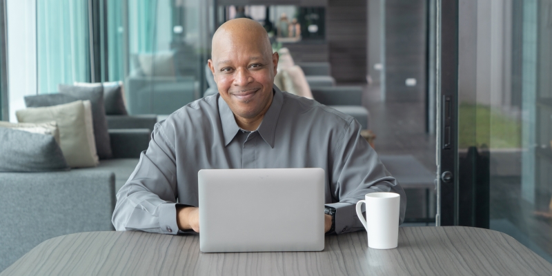 Um homem negro em um escritório, na frente de um computador. Imagem para ilustrar a matéria sobre carreira profissional.