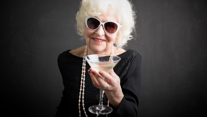 Uma senhora, com aparência de pessoa rica, oferecendo um drink. Imagem para ilustrar a matéria sobre o prêmio do BBB.