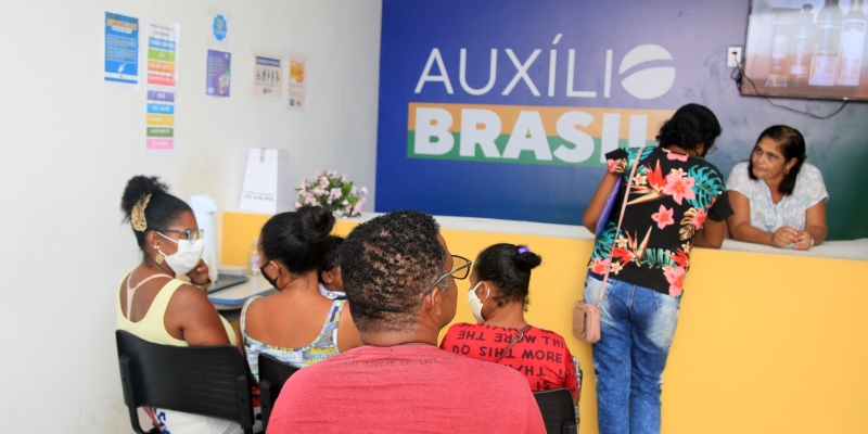 Uma agência do Auxílio Brasil com diversas pessoas sentadas esperando para serem atendidas. Imagem para ilustrar a matéria sobre Auxílio Brasil e Vale Gás.