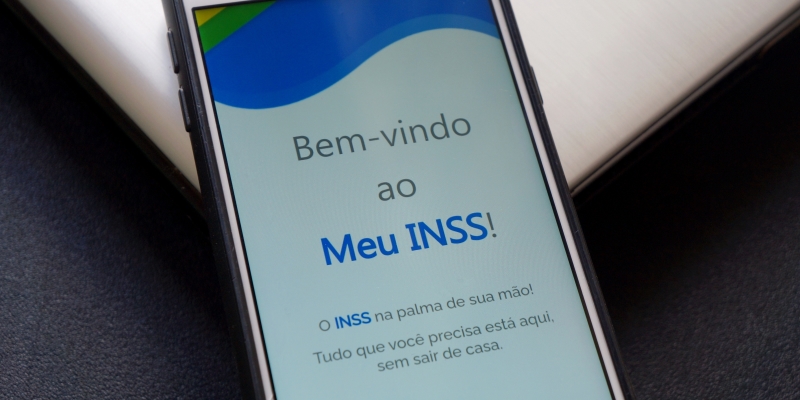 Um celular com o aplicativo do INSS. Imagem para ilustrar a matéria sobre pagamento do INSS suspenso.