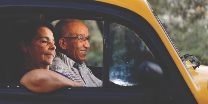 Dois idosos dentro de um carro. Imagem para ilustrar a matéria sobre comprar um carro.