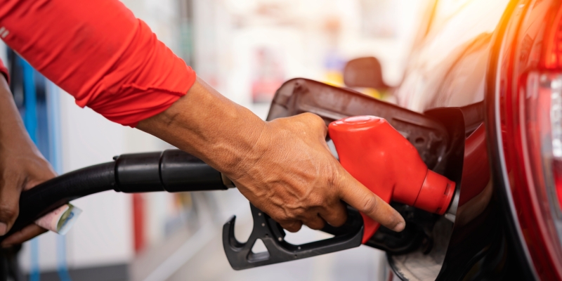 Mãos masculinas enchendo um tanque de carro com combustível. Imagem para ilustrar a matéria sobre deflação.