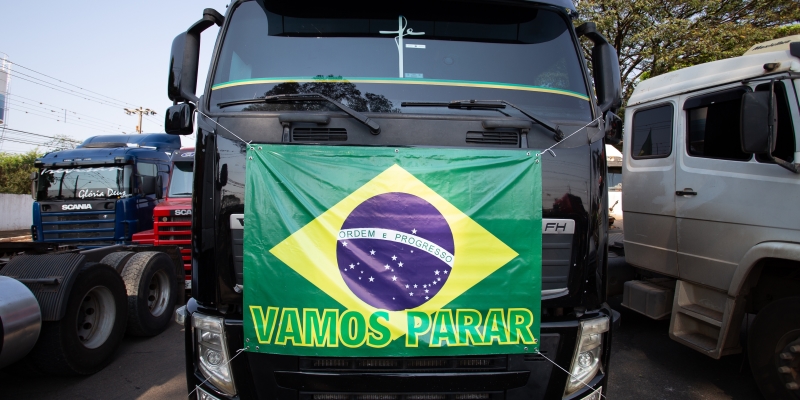 Um caminhão com uma bandeira do Brasil na frente, escrito 